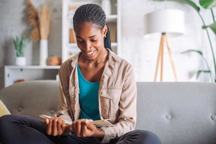 Books On How To Thrive In The Moment - Young woman reading a book on couch