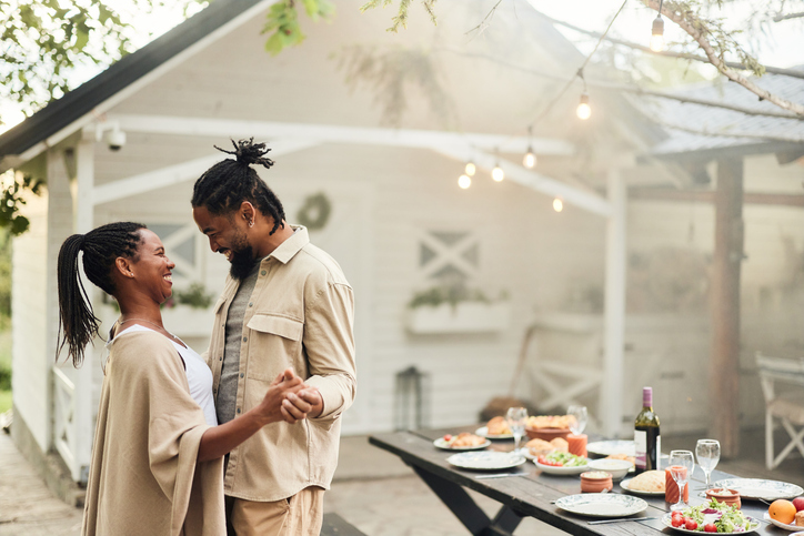 how to date well - Happy black couple dancing in the backyard.