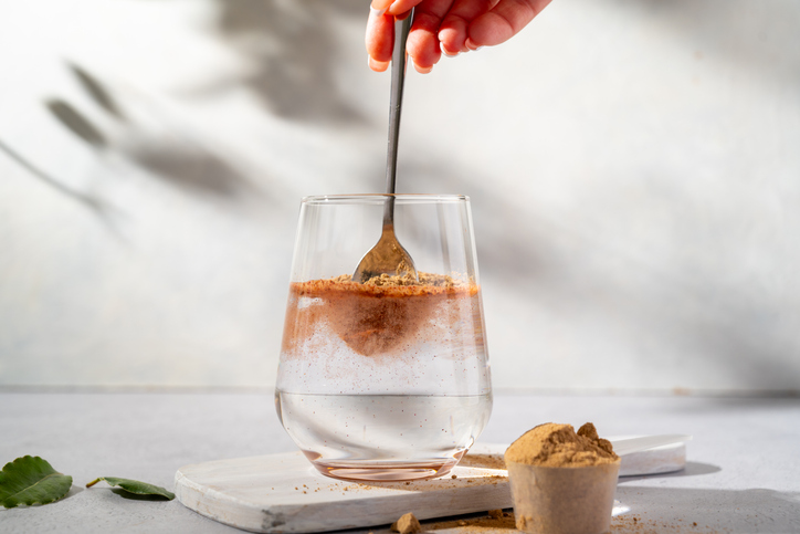 refresher recipes - Protein collagen pink powder, fruits and vegetables powder, food supplement in a glass with water