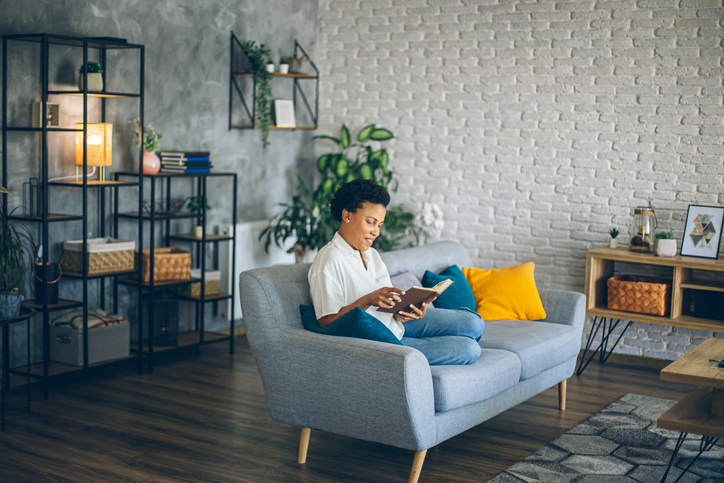 How To Create A Space For Relaxation - Woman enjoying a day off and reading a book on the couch