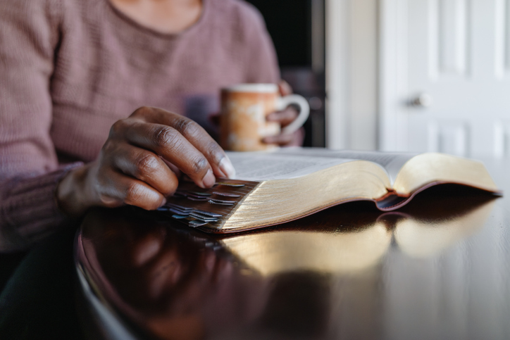 misconceptions about god - Woman Sits at Kitchen Table Reading Bible