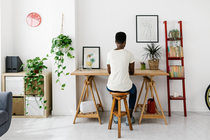 Creative young african woman working on laptop at home studio office