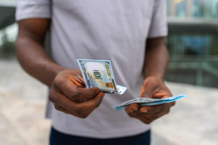 Man hands holding money dollar bills on urban street outdoor. Businessman hands counting currency money outdoors near office bank building. Unrecognizable man holding cash. Finance economy banking.