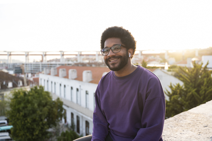 books on boundaries - Smiling man with in-ear headphones at sunset