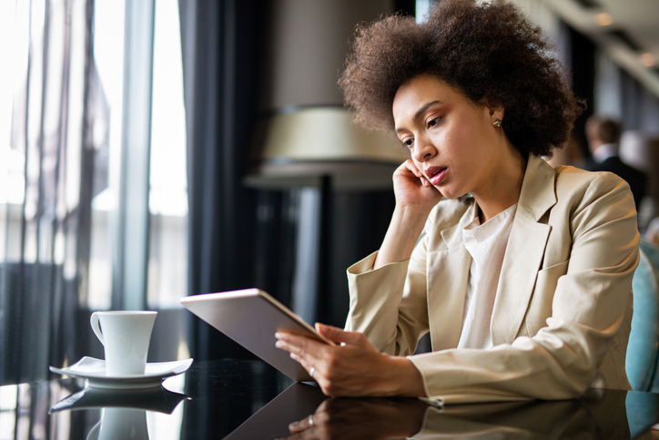 positive feedback at work - Young modern business black woman working using digital tablet while sitting in the office