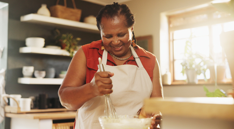 natural pain relief - Baking, smile and black woman with bowl in kitchen for cake, muffins or dessert at home. Happy, mix and mature African female person with utensil for preparing dough or bread recipe at house.