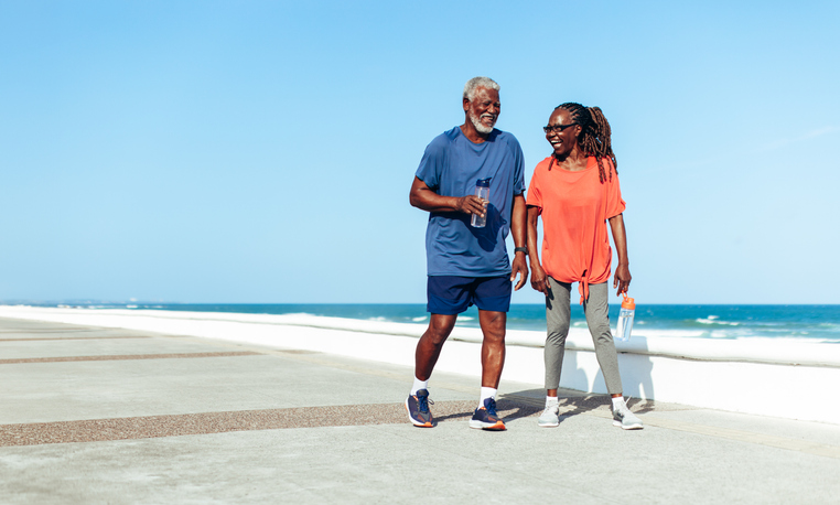 shifts in body's metabolism - Senior couple enjoying a sunny stroll on the seaside promenade