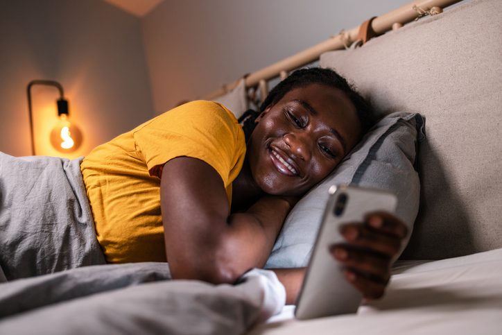 Young woman scrolling on social media before sleep
