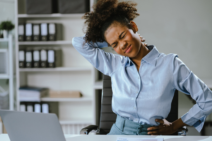 Businesswoman is doing a stretchy posture due to sitting in the office for too long, office syndrome concept.