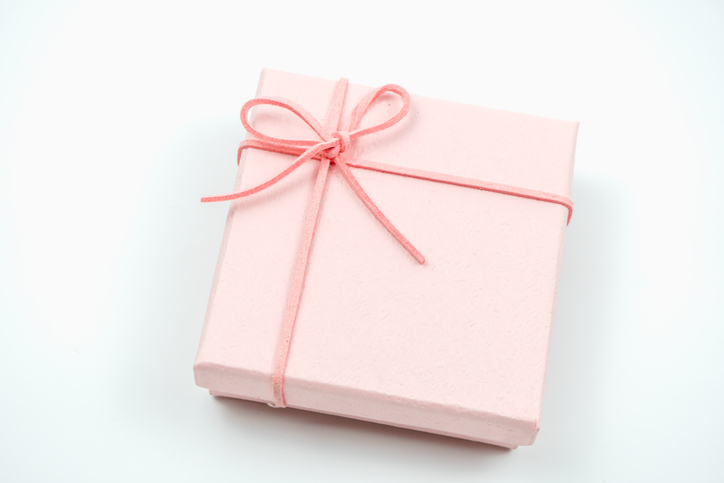 A beautiful pink gift box tied with a delicate ribbon, perfect for special occasions and celebrations. Ideal for packaging and decoration.