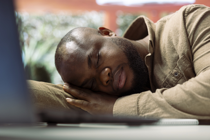 beating burnout - Successful businessman sleeping on his home desk while he works on laptop