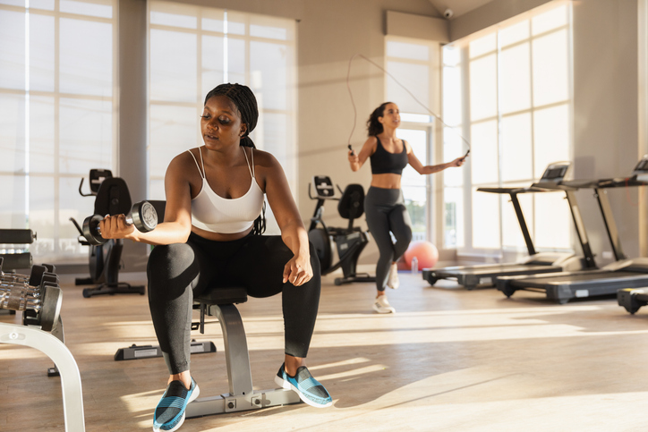 Healthy strong female African American plus-size holding dumbbells lifts weights exercise in gym. sport training weights fitness, Exercise to lose weight, take care of health.