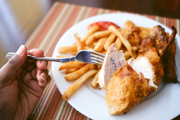 Woman Enjoys Spicy Chicken With Side of Fries