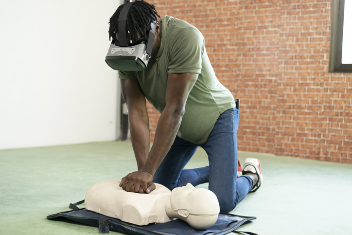 Young woman using virtual reality headset for online CPR training.