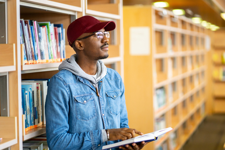 Black Bookstagram Accounts to Follow - Male student with a reference book