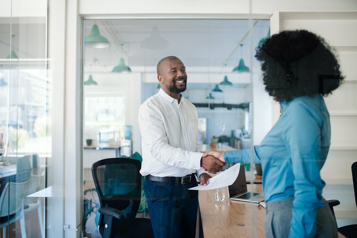how to stand out in job interview - Smiling manager welcoming a new employee to the office