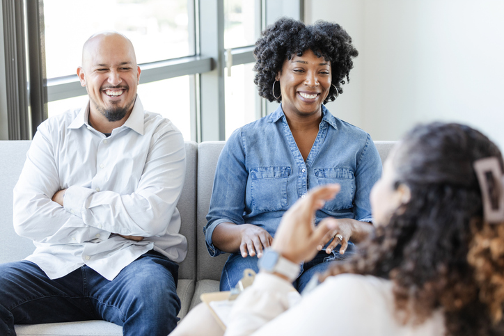 Cheerful couple talk with female counselor