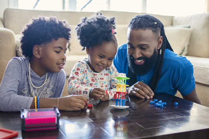family friendly games - Father playing table games with kids at home