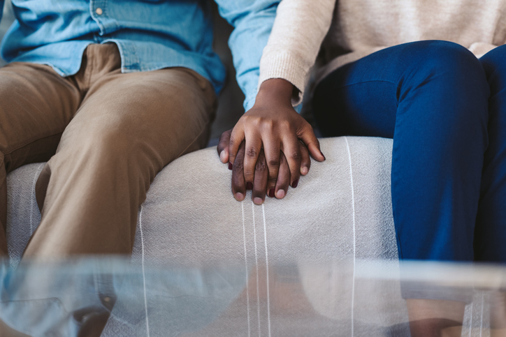 fall in love therapy - Young African American couple holding hands on a sofa