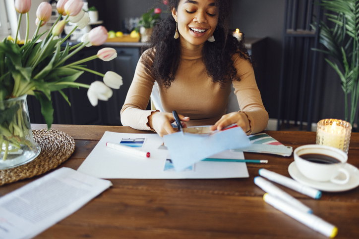 DIY christmas gifts - Smiling Young Woman Making Scrapbook At Home