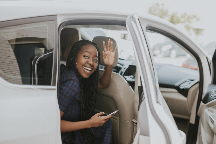 Mourn the End of the Year - Happy black woman waving goodbye from a car