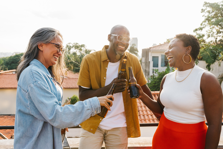 warning labels on alcohol - Diverse friends cheering with drinks outdoors, celebrating a joyful moment together