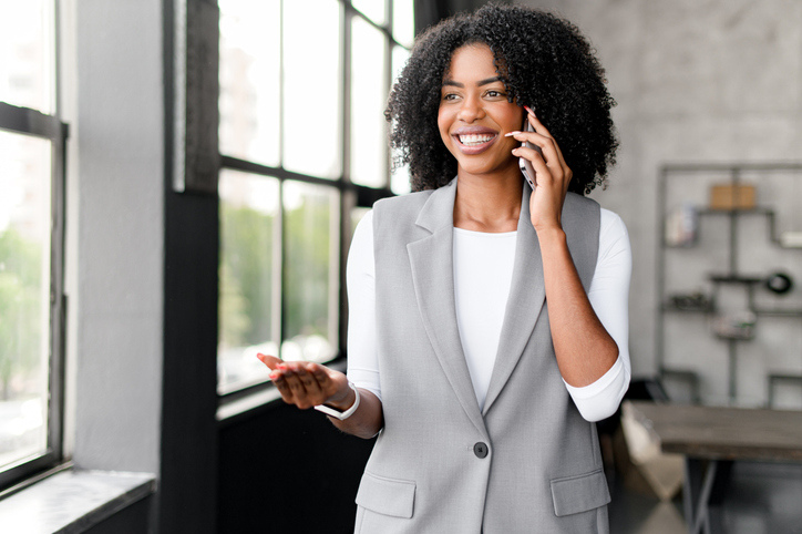 A confident African-American businesswoman enjoys a light-hearted moment talking on her phone