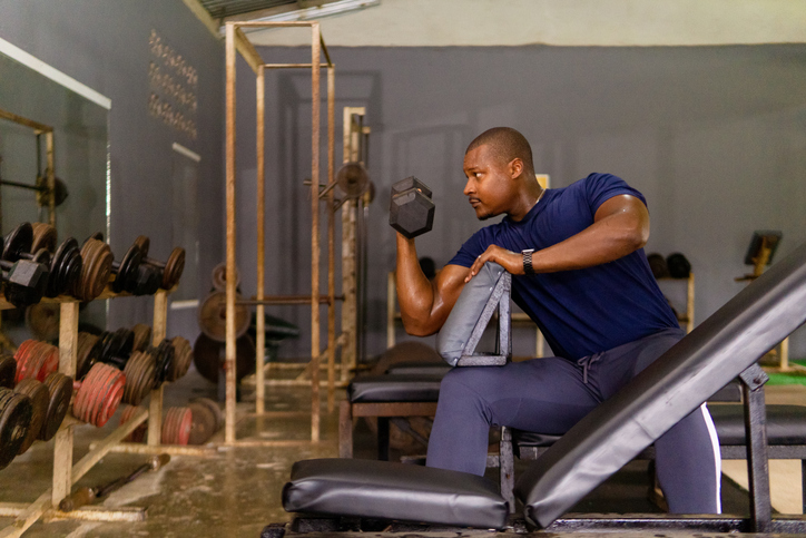 Determined bodybuilder lifting dumbbell during intense workout session