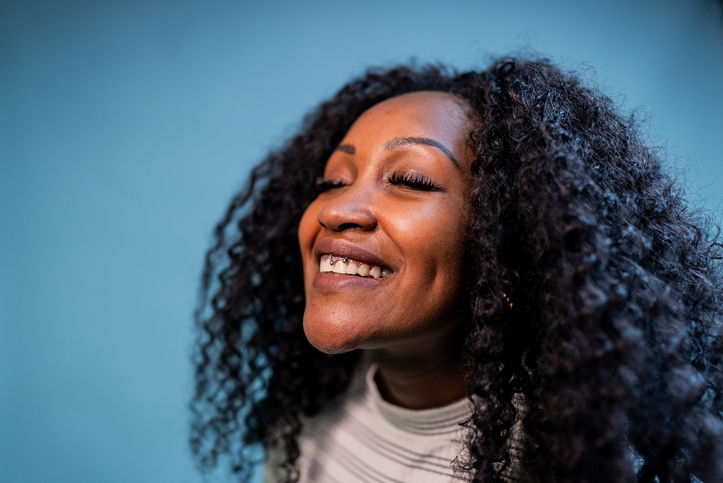 Mid adult woman with eyes closed on a blue background