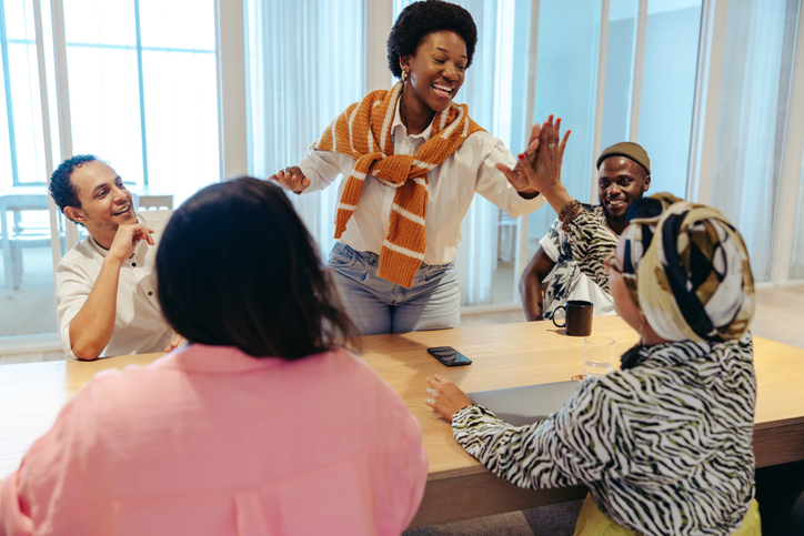Diverse group of colleagues celebrating success in teamwork with a high-five
