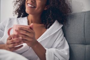 Woman in a bathrobe sitting in bed