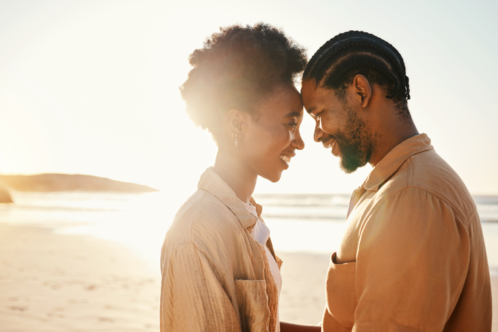 Beach sunset, forehead and happy black couple bonding, connect and enjoy relax summer vacation together. Love, flare and African people support, care and affection on holiday, outdoor date or travel