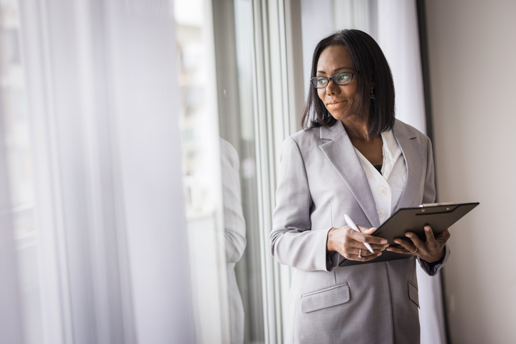 Beautiful business woman looking through the window and concentrating