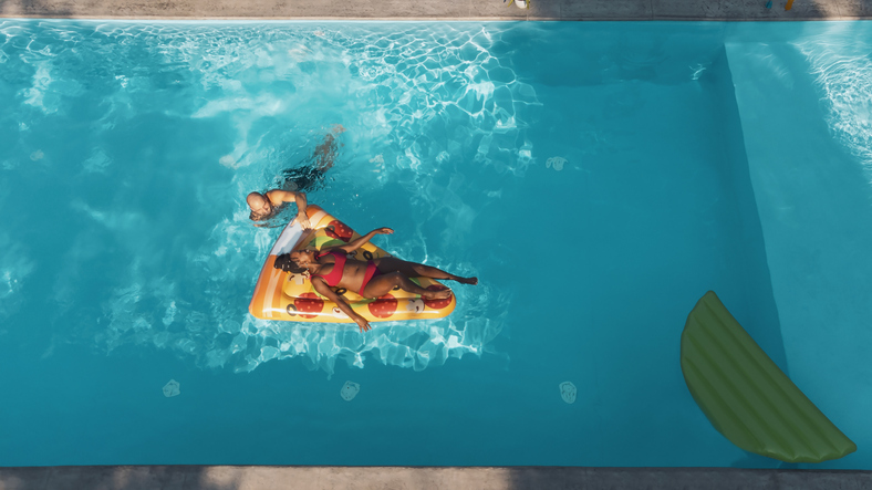 Multiracial couple relaxing in the swimming pool